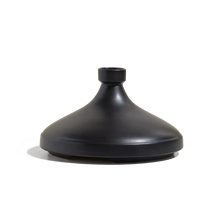 The CX - Tagine is a matte black, cone-shaped ceramic vase featuring a small circular opening at the top, displayed on a plain white background.